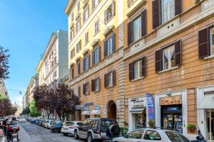 una concurrida calle de la ciudad con coches estacionados frente a los edificios en Rione XXII Apartments, en Roma