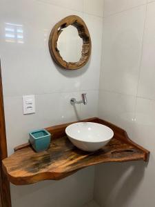 a bathroom with a white sink and a mirror at Chalé Sienna Ar condicionado Pousada 35knots Brasil in Luis Correia