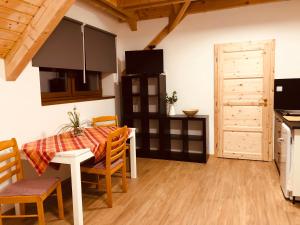 cocina y comedor con mesa y sillas en Apartmány Kunc, en Bedřichov