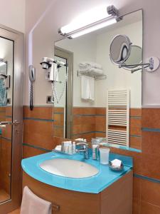 a bathroom with a sink and a mirror at Hotel Domus in Marina di Massa +33 photos