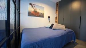 een slaapkamer met een bed met een blauw dekbed bij Apartament MAGMA z basenem Morska Klifowa Rewal in Rewal