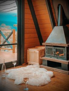 a room with a stove and two glasses of wine at URUBICI - Cabana da Montanha in Mundo Novo