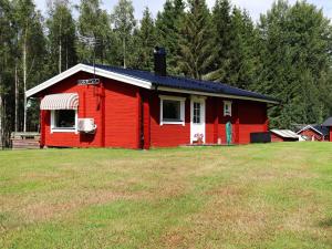 ein rotes Haus auf einem Feld in der Unterkunft Holiday home DALS-LÅNGED in Dals Långed