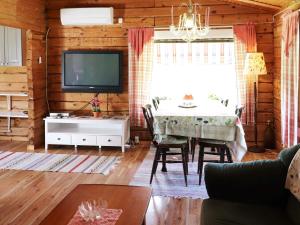 ein Wohnzimmer mit einem TV und einem Esstisch in der Unterkunft Holiday home DALS-LÅNGED in Dals Långed