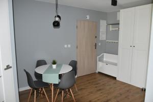 - une cuisine et une salle à manger avec une table et des chaises dans l'établissement Apartament Rodzinny Jantar Park, à Jantar