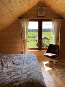 a bedroom with a bed and a chair and a window at Zamieszkaj na wsi blisko Warszawy in Borucza
