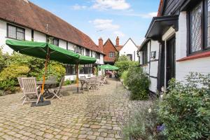 a patio with chairs and a green umbrella at The Crown in Amersham