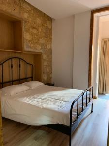 a bed in a bedroom with a brick wall at QuimPecável in Figueira da Foz +27 photos