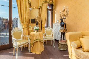un soggiorno con specchio, tavolo e sedie di La Veneziana Boutique Rooms a Venezia