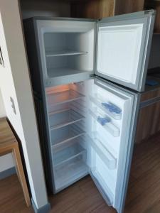 an empty refrigerator with its door open in a kitchen at Depto.Barcelona Rucakawi in Temuco