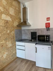 a kitchen with white cabinets and a counter top at QuimPecável in Figueira da Foz