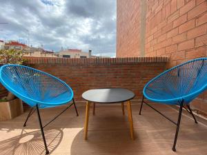 two blue chairs and a table on a patio at Camp Nou Nueva Casa in El Arrabal