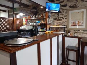 a bar with a counter with a tv on the wall at LAST 12K in Santiago de Compostela