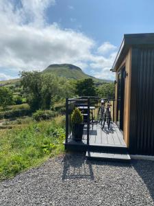 a bike parked on a porch of a house at Glens glamping in Cushendall