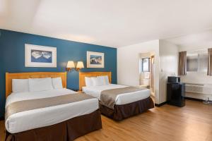 two beds in a hotel room with blue walls at Skylark Shores Resort in Lakeport