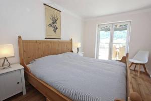 1 dormitorio con 1 cama, 1 silla y 1 ventana en Appartement Sonnenblick, en Fliess