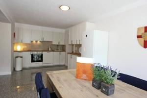 a kitchen with a wooden table and a white refrigerator at Appartement Sonnenblick in Fliess