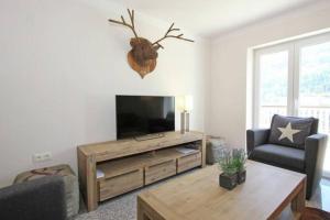 a living room with a flat screen tv and a table at Appartement Sonnenblick in Fliess