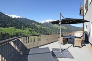 a balcony with a table and an umbrella at Appartement Sonnenblick in Fliess
