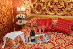 a bed with a tray with a bottle of wine and glasses at La Veneziana Boutique Rooms in Venice