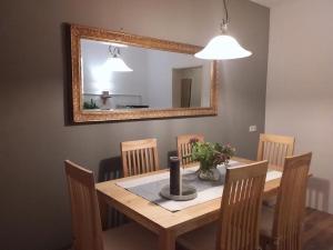 een eettafel met stoelen en een spiegel bij Luna et Sol - Haus am See großes Apartment in Seehausen