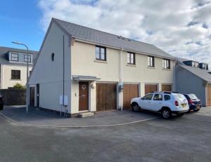 a house with a car parked in a parking lot at Burry Port Harbour Apartment in Burry Port
