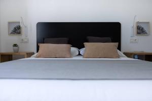 a large white bed with two pillows on it at Island Home Fuerteventura in Corralejo