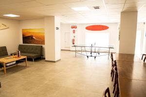 a waiting room with a table and chairs at Hostel Playa de Merón in San Vicente de la Barquera