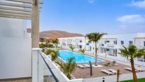 a large white swimming pool in front of a house at Island Home Fuerteventura in Corralejo