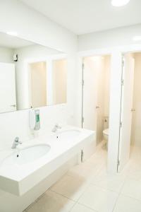 a white bathroom with two sinks and a toilet at Hostel Playa de Merón in San Vicente de la Barquera +5 photos