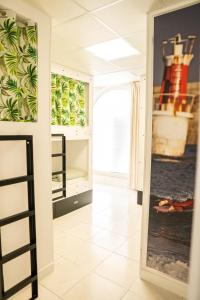 a hallway with a door to a room with a painting on the wall at Hostel Playa de Merón in San Vicente de la Barquera