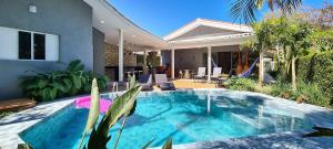 a swimming pool in front of a house at Casa com piscina perto da praia de Riviera in Riviera de São Lourenço
