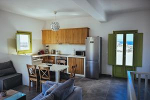 a kitchen and living room with a table and a refrigerator at Abelonas Houses in Foinikiá