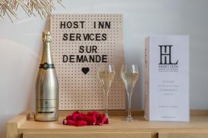 Una botella de champán y dos copas en una mesa. en HOST INN - CŒUR VIEUX LYON & SPA en Lyon