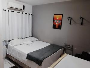 a small bedroom with two beds and a window at Pousada Surya in Porto Velho