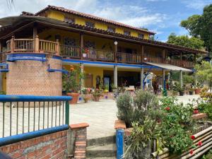 a house with a balcony and a courtyard at Castillo de Cascadas Finca Hotel in Salamina