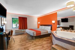 una camera d'albergo con un letto e una vasca da bagno di Motel 6-Norcross, GA a Norcross