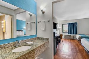a bathroom with a sink and a room with a bed at Motel 6-Norcross, GA in Norcross
