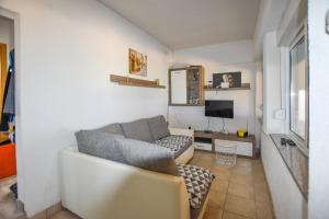 a living room with a couch and a tv at House Romano in Neviđane