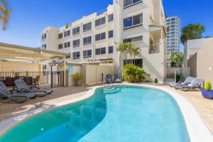 a swimming pool in front of a building at Paradis Pacifique in Maroochydore