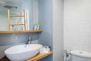 ein Badezimmer mit einem weißen Waschbecken und einem WC in der Unterkunft Victoria Place AMORA by AlohaMalaga in Málaga