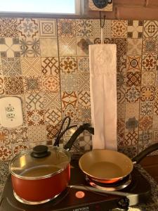 a stove top with a pot and a pan on it at Chalé do Rio in Barreirinhas