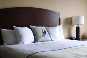 a bed with white pillows and a brown headboard at Swinomish Casino & Lodge in Anacortes