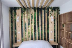 a bedroom with a bed with a wall of bamboo at Le Nid d'Opale in Berck-sur-Mer