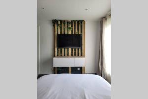 a bedroom with a bed and a flat screen tv at Le Nid d'Opale in Berck-sur-Mer