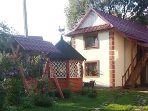 a small house with a gazebo in the yard at Shelter Pid Lypamy in Mykulychyn