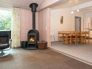 a living room with a fireplace and a dining room table at 20 person holiday home in Herning in Herning