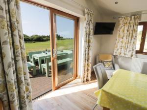 a room with a sliding glass door with a table and a patio at Caer Moel in Llanwnda