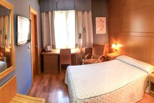 グラナダにあるレイノ デ グラナダのベッドルーム1室(ベッド1台、デスク、窓付)