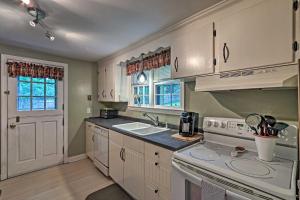 a kitchen with white cabinets and a white stove top oven at Historic Essex Home with Large Yard Near Downtown! in Essex
